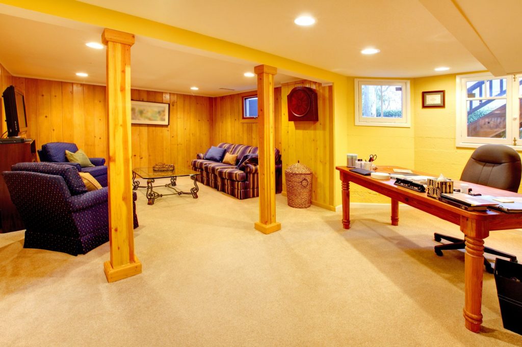 yellow basement living room with office desk.